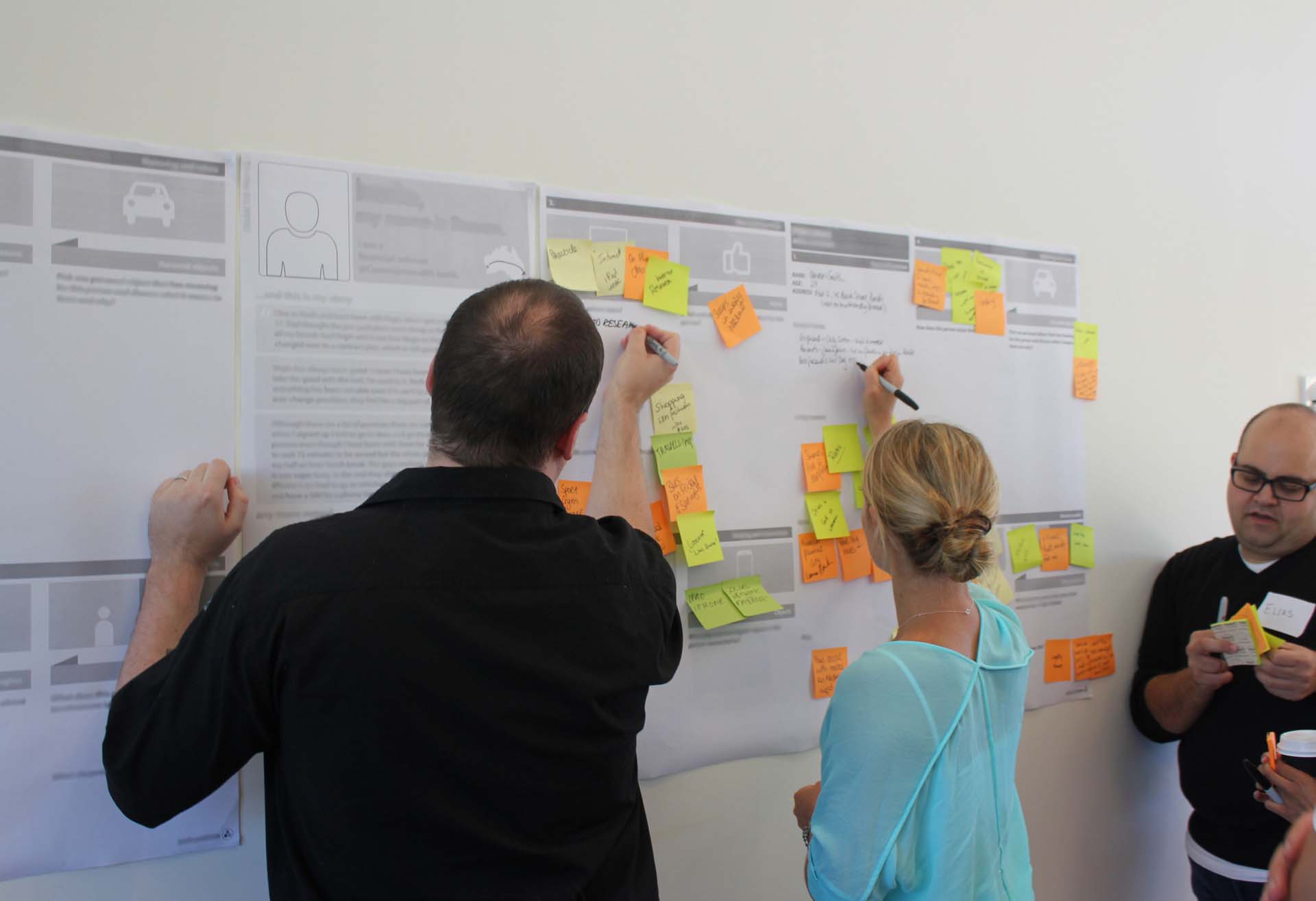 Three Proto employees making notes on a Customer Journey Map