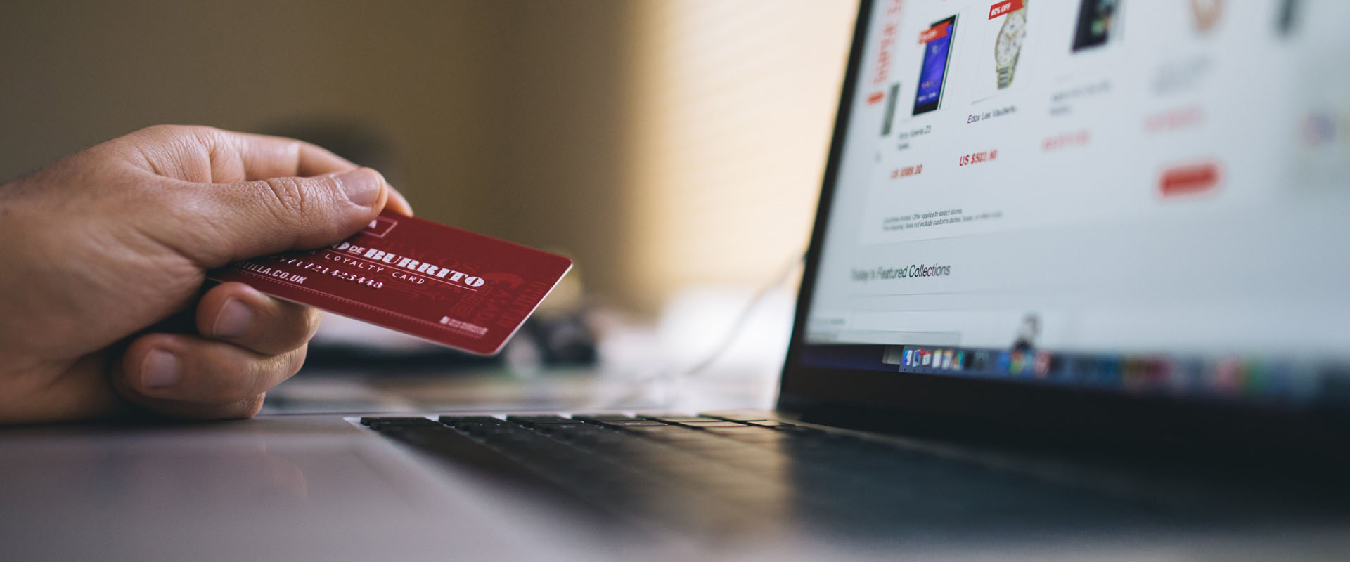 Hand holding a credit card whilst using ecommerce platform