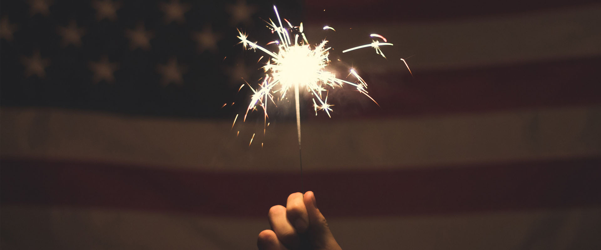 Sparkler in front of an American flag representing Service Design delight